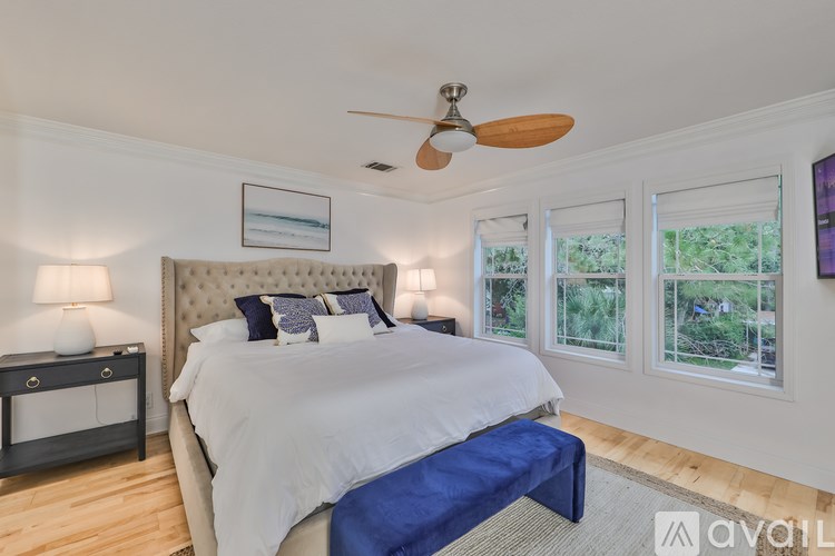 A bedroom with a large bed and a ceiling fan.
