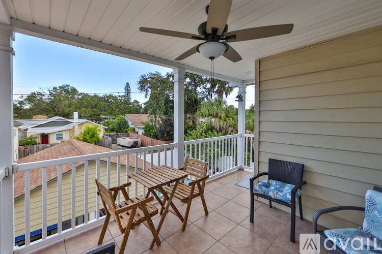 A patio with a table and chairs and a ceiling fan.