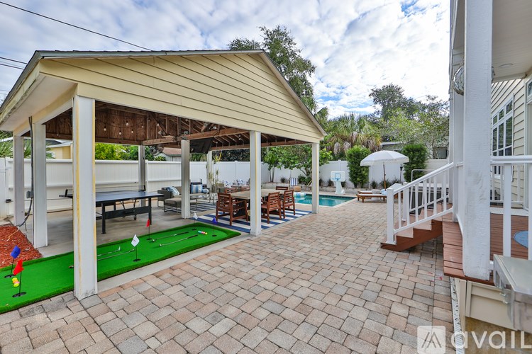 A patio with a mini golf course and a pool.