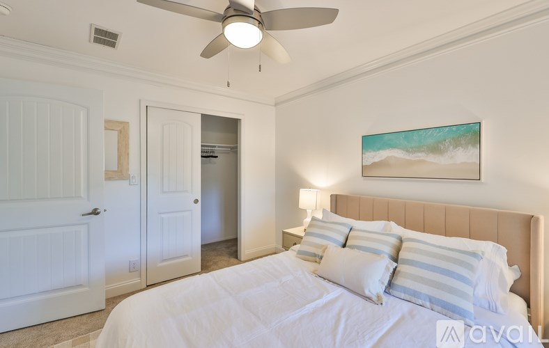 A bedroom with a large bed and a ceiling fan.