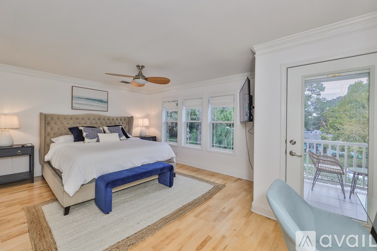 A bedroom with a large bed and a ceiling fan.