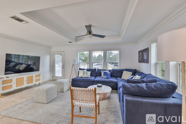 A living room with a blue sofa and a wooden chair.