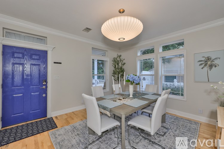 A dining room with a blue door and a table set for four.