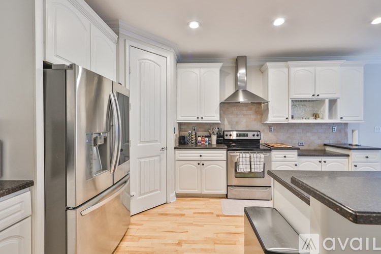 A modern kitchen with white cabinets and stainless steel appliances.