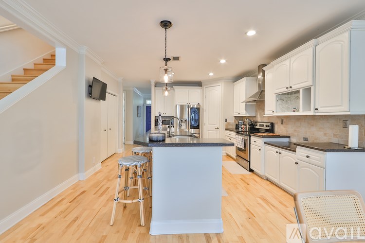 A kitchen with white cabinets and a wooden floor.