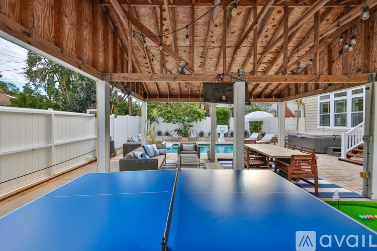 A blue table is in the middle of a wooden deck.