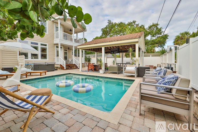 A pool with a white chair and a blue and white striped towel.