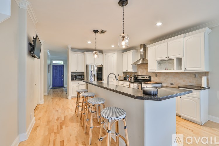 A kitchen with white cabinets and a black countertop.
