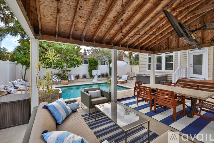 A patio with a pool and furniture.