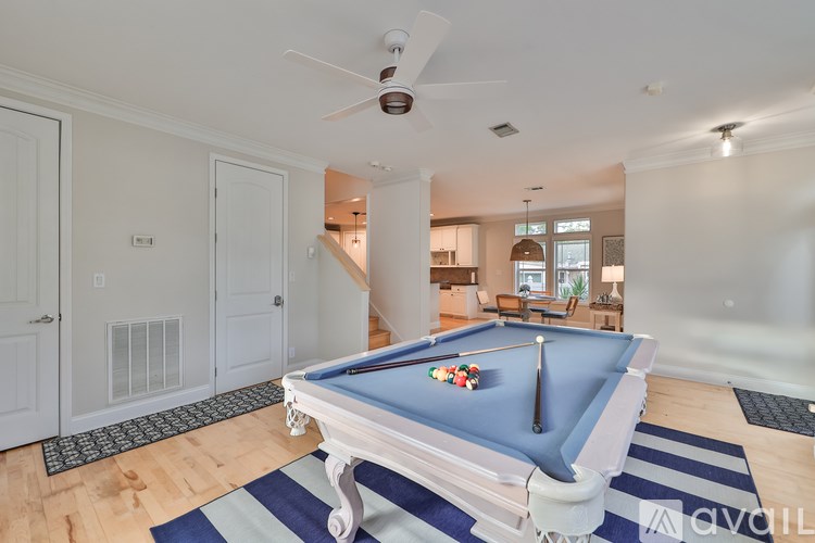 A pool table with a blue cloth and white cue is in the center of the room.