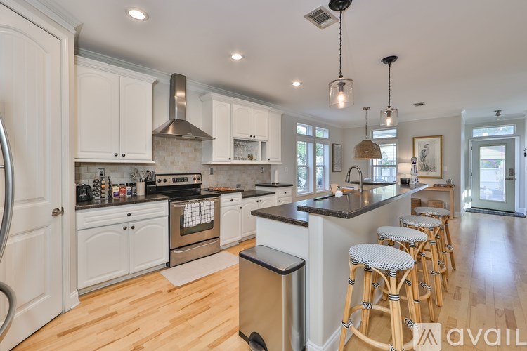 A kitchen with white cabinets and a black countertop.