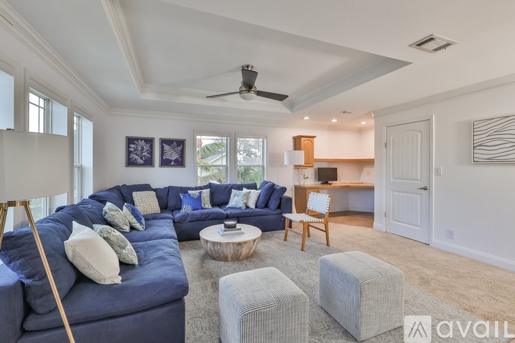 A living room with a blue couch and a wooden chair.