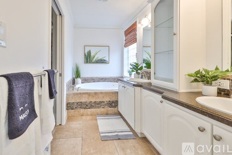 A bathroom with a tub, sink, and mirror.