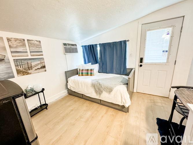 A bedroom with a bed, a chair, and pictures on the wall.