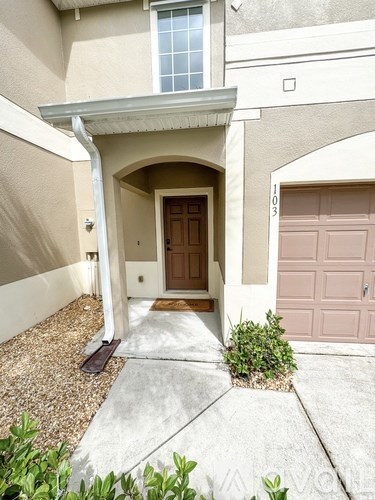 A beige house with a brown door and a window.