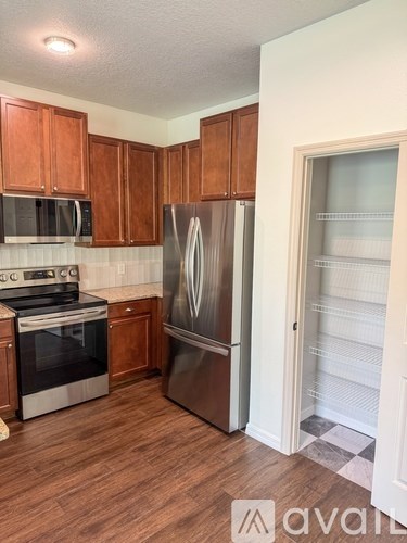 A kitchen with wooden cabinets and a stainless steel refrigerator.