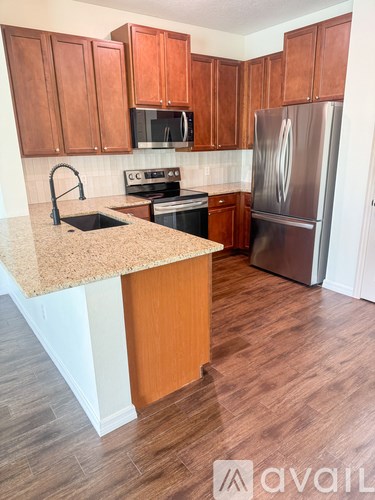 A kitchen with wooden cabinets and a granite countertop.