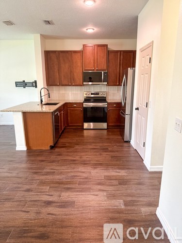 A kitchen with wooden cabinets and a refrigerator.