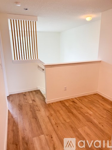 A room with wooden flooring and a window with wooden blinds.