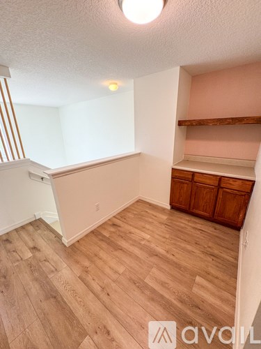 A room with wooden flooring and a cabinet against the wall.