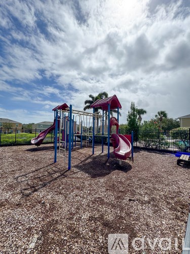 A playground with a red slide and a blue structure.