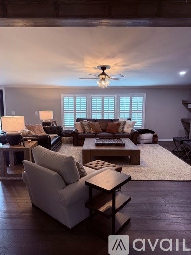 A living room with a white couch and a wooden coffee table.