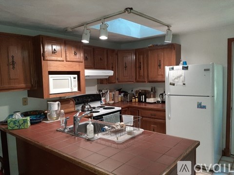 A kitchen with brown cabinets and a white fridge.