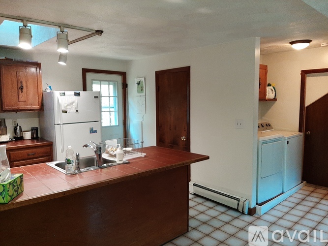A kitchen with a white fridge and a brown counter.