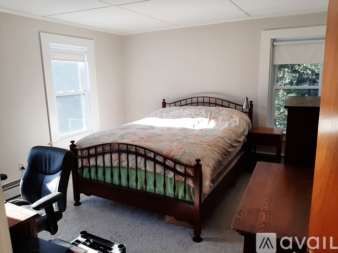 A bedroom with a bed, desk, and chair.