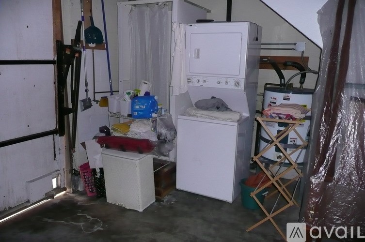 A small, cluttered laundry room with a washer and dryer.