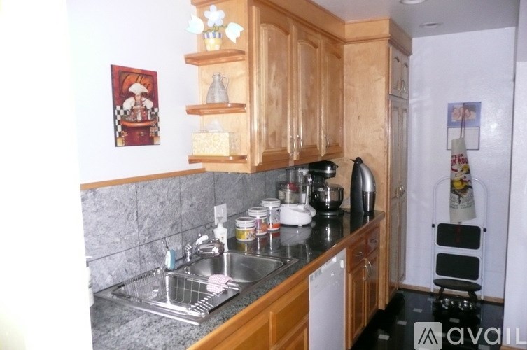 A kitchen with wooden cabinets and a black countertop.