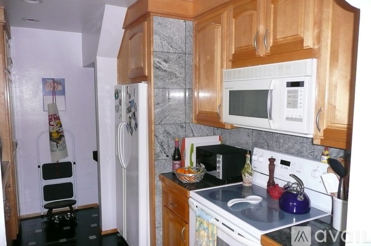 A kitchen with wooden cabinets and a white fridge.