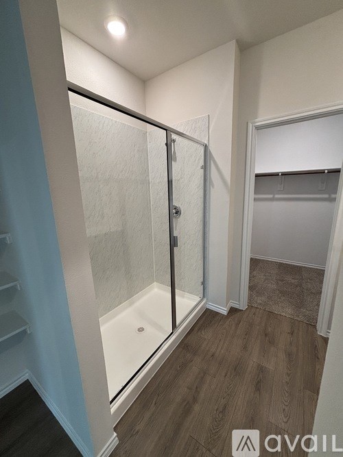 A bathroom with a walk-in shower and a towel rack.