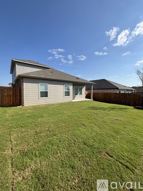 A house with a grey roof and a brown fence.