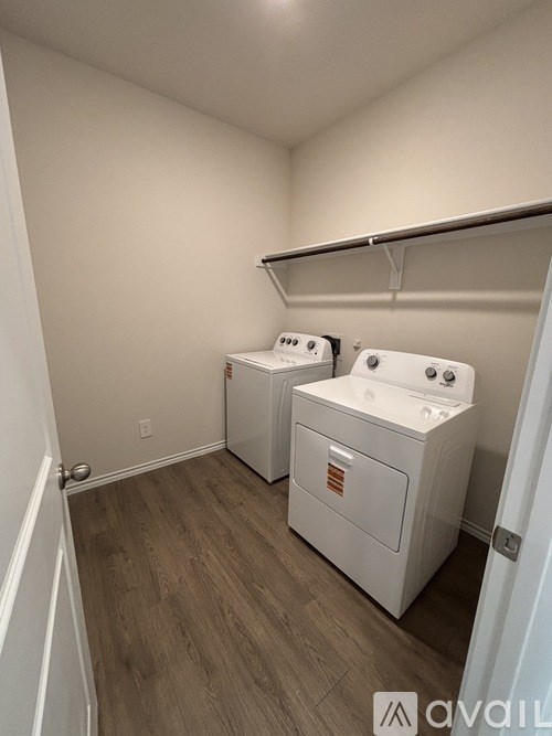 A laundry room with two washers and a dryer.