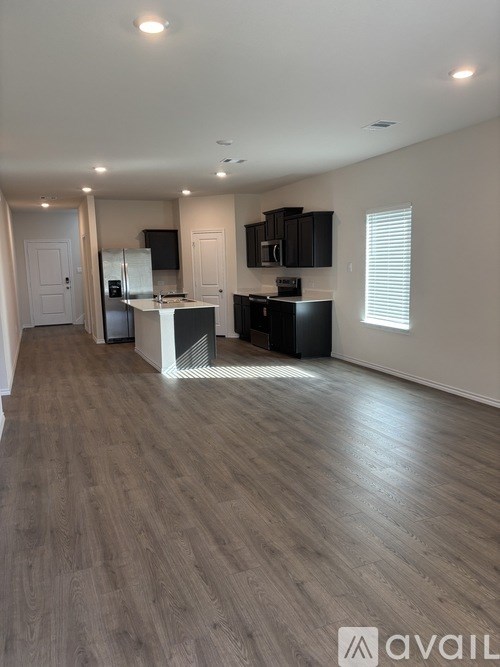 A kitchen with a refrigerator, microwave, and oven.