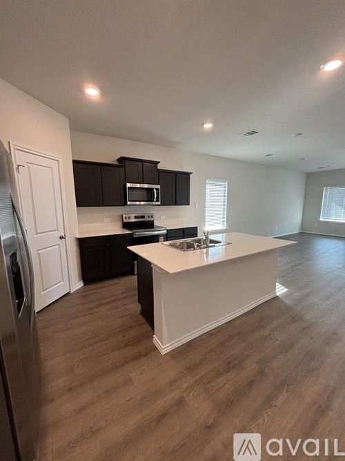 A kitchen with a white island and wooden floors.