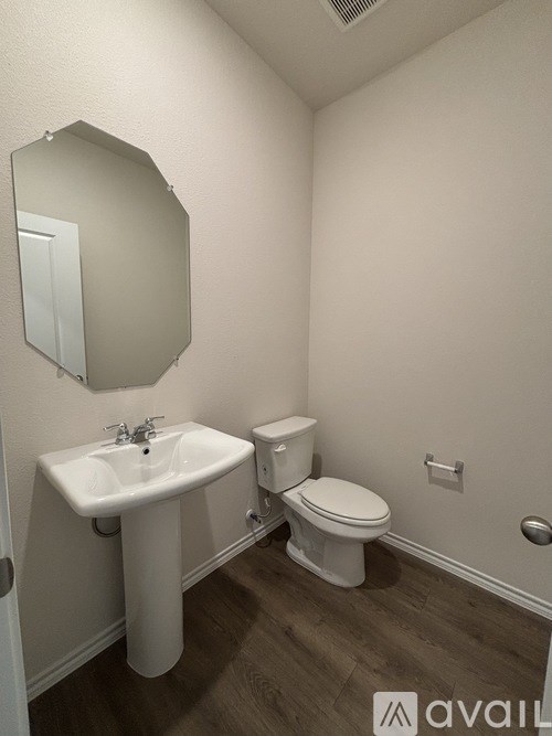 A bathroom with a sink, toilet and mirror.