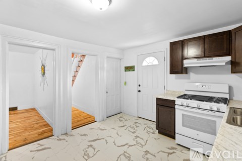 A kitchen with a white stove top oven and a white fridge.