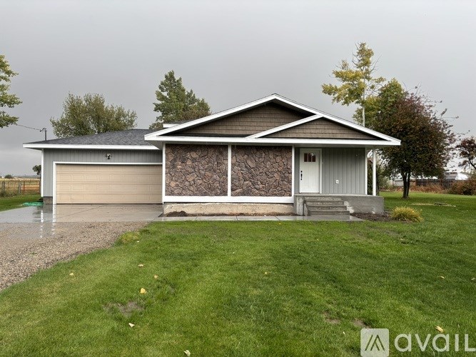 A house with a grey roof and a brown garage door.