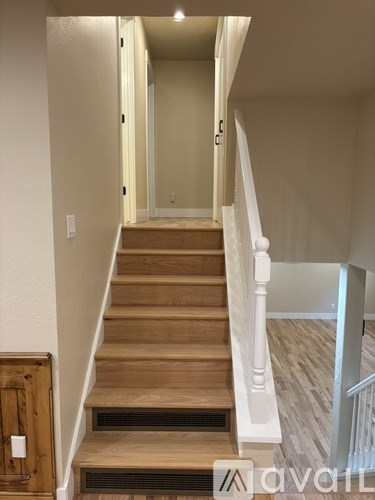 A wooden staircase with a white railing.