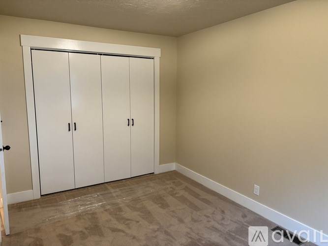 A room with a white door and a carpeted floor.