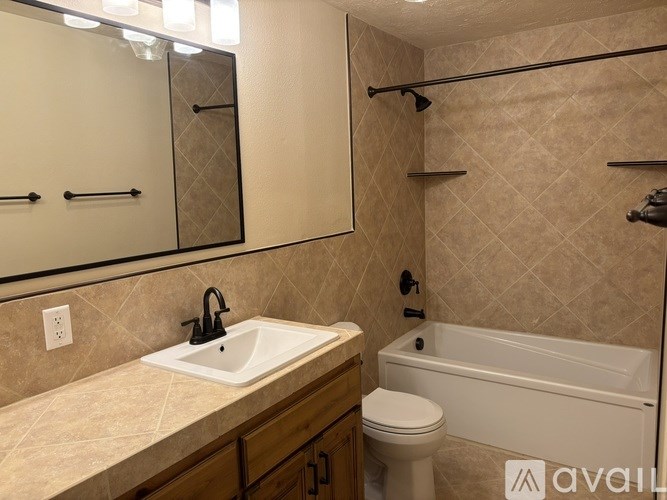 A bathroom with a sink, toilet, and bathtub.