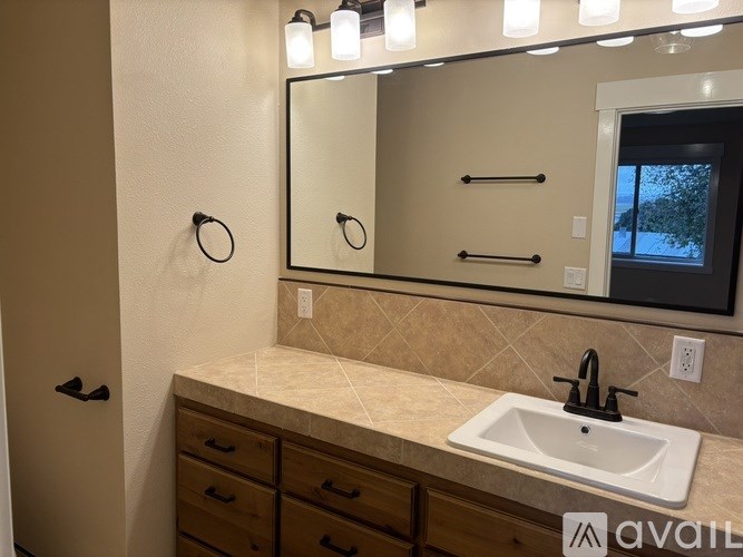 A bathroom with a sink, mirror, and light fixture.