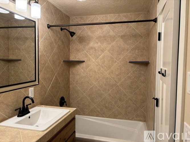 A bathroom with a sink, mirror, and bathtub.