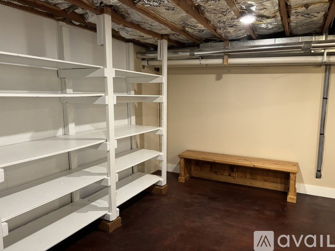 A room with white shelving and a wooden bench.
