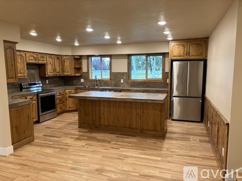 A kitchen with wooden cabinets and a large island.