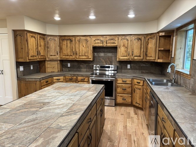 A kitchen with wooden cabinets and a stone countertop.