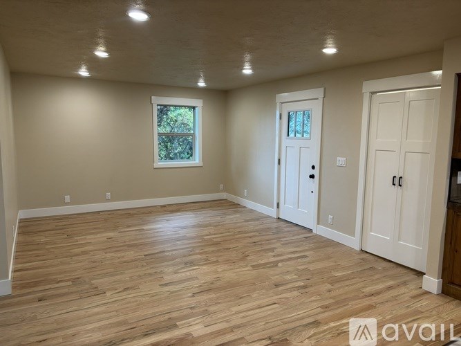 A room with wooden flooring and white walls.