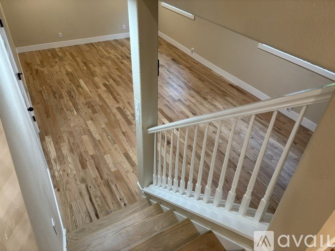 A wooden staircase with white railings.